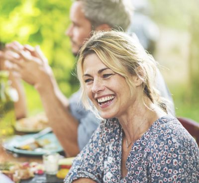 Blonde women enjoying a meal outdoors with her spouse.