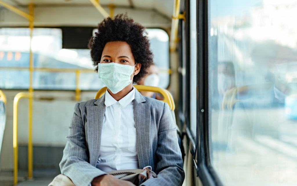 Women with face mask, riding on public transit.
